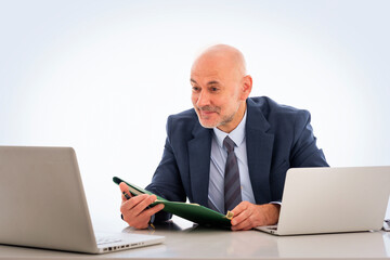 Confident businessman wearing suit and tie and using his laptop against isolated white background