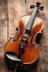 Fototapeta premium Intimate close-up of a vintage violin on old wooden table. Soft shadows and dramatic lighting highlight its rich grain, evoking a broken violin's quiet history with desaturated memories.