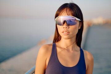 Portrait of a young woman enjoying her summer vacation by the sea, wearing a stylish swimsuit and...