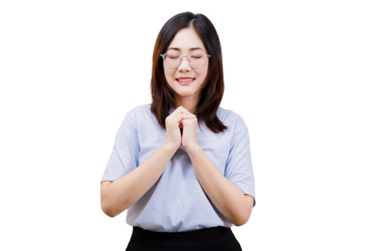 A woman with glasses is standing with her hands clasped together, expressing a gesture of prayer or gratitude.
