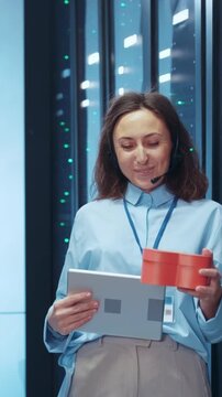 A professional individual using a laptop while beside a red container in a technology environment