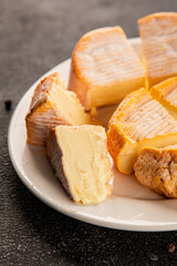 Cheese plate camembert, brie, munster french cheese tasty snack fresh delicious gourmet food background on the table rustic food top view copy space
