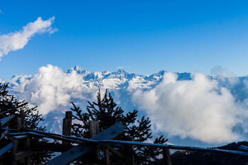Cloud-Kissed Peaks and Wooden Viewpoint
