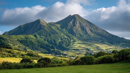 Naklejka premium Majestic Mountain Vista: The verdant landscape of a picturesque mountain with rolling hills unfolds under a brilliant blue sky, evoking a sense of serenity and awe.