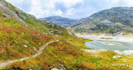 a hiking path through the tundra in high altitude mountain with glacier water, Norway summer, hiking experience