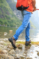 low angle of a man wearing tracking boots stepping in a stream, Norway summer, hiking experience