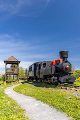 Old steam locomotive and passenger car standing on the tracks in Viglas, Slovakia