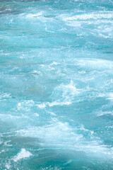Fototapeta premium Close up of the sapphire blue water running in Dønfoss river in summer Norway, background