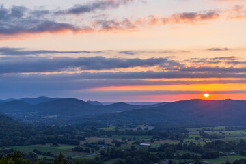 Breathtaking Sunset illuminating Green Valley and Majestic Mountains
