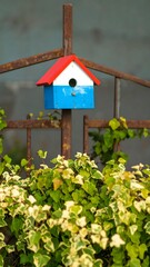 Colorful birdhouse on a fence (1)