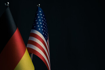 Flag United States and Germany on dark background.