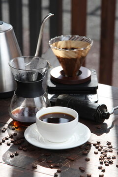 Pour-over filter dripper brewing coffee into glass Alternative coffee brewing method, pure over, teapot on wooden table

