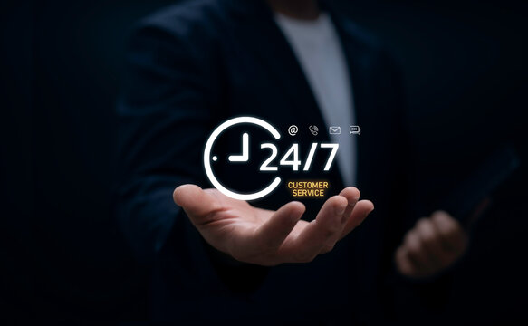 Businessman holding 24/7 customer service icon with contact symbols for email phone and chat representing nonstop support online communication and business reliability concept