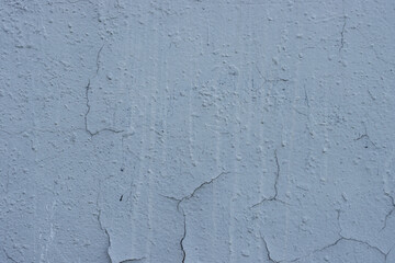 An old, worn concrete wall with slight cracks. Damaged weathered plaster.