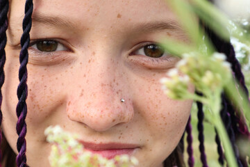 A twelve year old girl with freckles on her face, close-up