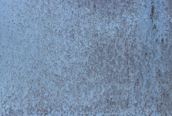 Close-up of a wall with damaged blue paint.