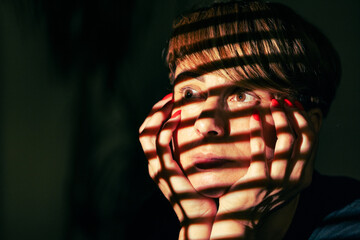 Woman Looks Thoughtfully Under Pattern Shadows