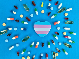Colorful arrangement of various capsules heart symbolized by pride colors on a vibrant blue...