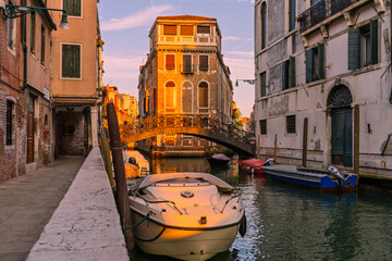 Venetian canal with bridge and golden sunset light