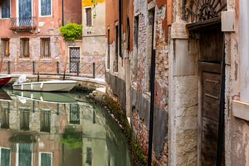 Scenic canal with reflections and rustic Venetian walls