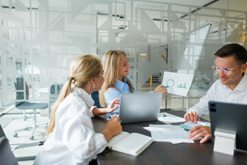 Team collaborating on project strategies in a modern office space with engaging visuals and digital...