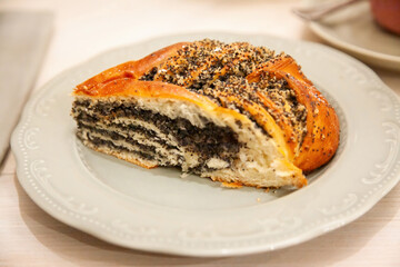 Delicious poppy seed pastry sits on a decorative plate in a cozy cafe