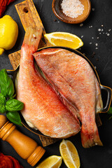 Raw red sea bass or perch on table, vertical photo