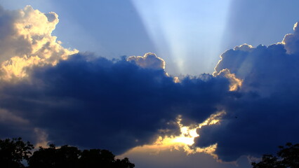 Dramatic sunset sky with dark clouds and sun rays
Majestic sky scene with golden sunlight breaking through dark storm clouds, creating dramatic rays of light. 