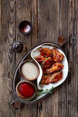 Fried chicken wings with sauces on wooden background top view vertical photo