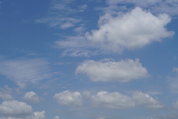Obraz premium Fluffy white clouds against a vibrant blue sky, creating a serene, peaceful atmosphere
