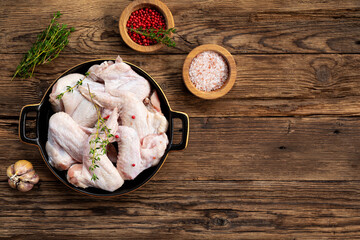 Raw chicken wings and spices before cooking top view wooden background copy space for text