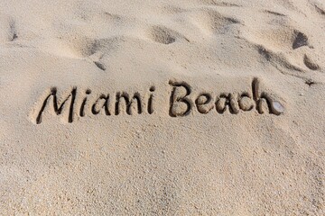 Fototapeta premium Miami Beach Text Carved Into Sand On A Sunny Day In Florida Vacation Destination