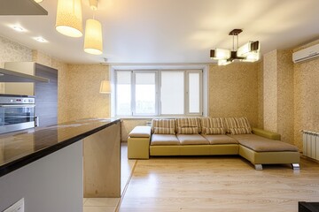 cozy interior features a modern kitchen island, a comfortable L-shaped sofa by the window, and...