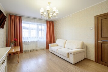 cozy room with a sofa, curtains, and a chandelier