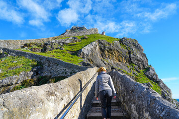 Woman on stone stairway of San Juan de Gaztelugatxe