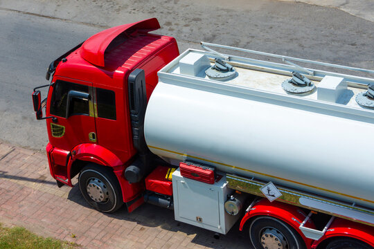 Fototapeta Truck with a tank of flammable liquid fuel wait at a storage facility waiting for dispatcher to send it on a trip