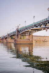 Obraz premium Pont Saint-Pierre à Toulouse, France, au-dessus de la Garonne, avec reflets dans l’eau au coucher du soleil.