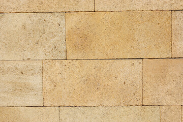 Yellow brick wall texture. House stone wall texture background. Stone wall as background or texture. Part of a stone wall.  Ideal for backgrounds, textures, and construction-related