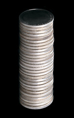 Column of neatly stacked silver coins, against a black background. Stack of twenty-eight circulated...