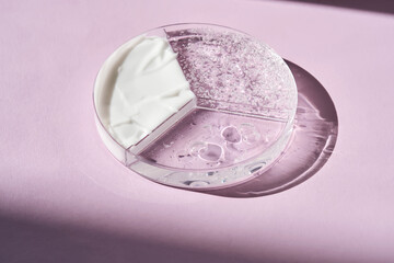 Textures of cream, cosmetic oil and serum in a petri dish. Purple background.