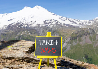 Trade tariff wars symbol. Concept word Tariff wars on beautiful black blackboard. Beautiful stone...