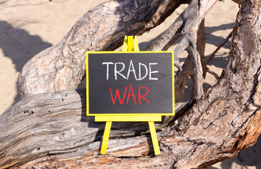 Trade war symbol. Concept word Trade war on beautiful black blackboard. Beautiful old tree...