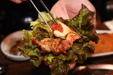 Korean bbq. ssam : eat pork wrapped in lettuce leaves