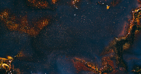 Golden spatter. Water background. Defocused blue orange yellow color sparkling ink liquid particles spreading on creative abstraction.