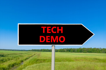 Tech demo symbol. Concept word Tech demo on beautiful black road sign. Beautiful green grass field...