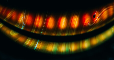 Glow oil mix. Ink stream blur. Colorful dye blend in water gasoline surface. Red orange green pigment arch abstract black background.