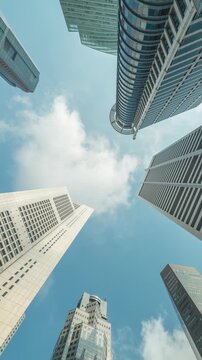 Singapore time lapse city skyline looking up under skyscraper building business district (vertical)