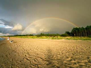 Letnia tęcza nad plażą, morska plaża, człowiek, pies, lato, wakacje. © malgo_walko