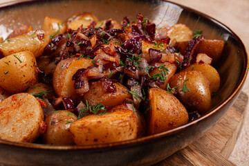 Crispy golden potatoes topped with sautéed onions and herbs served in a rustic bowl