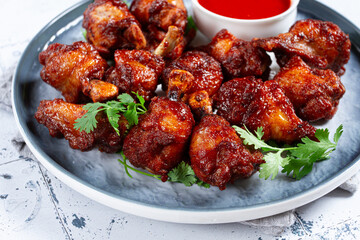 Crispy pieces of fried chicken, on a plate with sauce and herbs, in a modern kitchen environment, there are no people